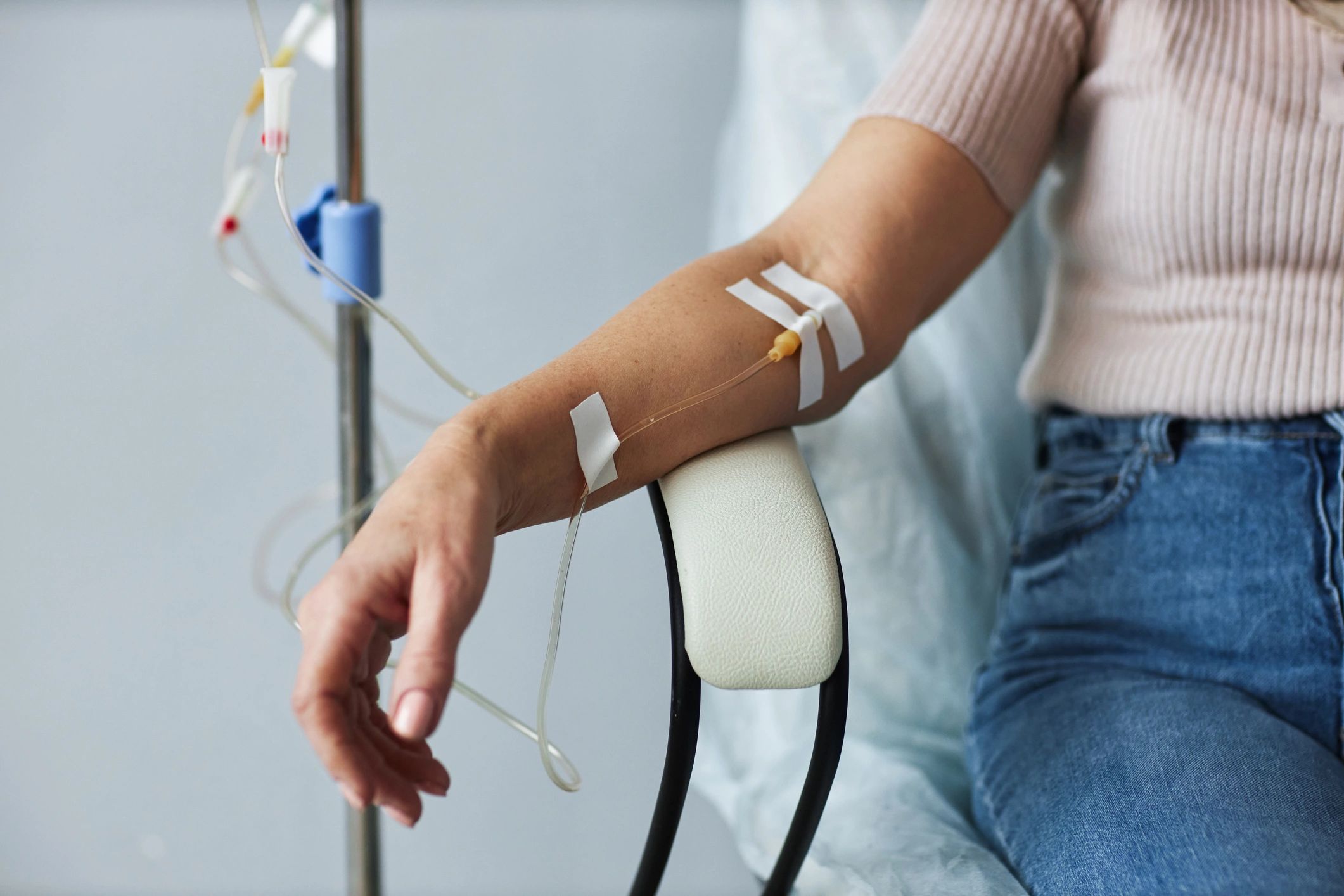 Person receiving intravenous therapy with an IV line in their arm.