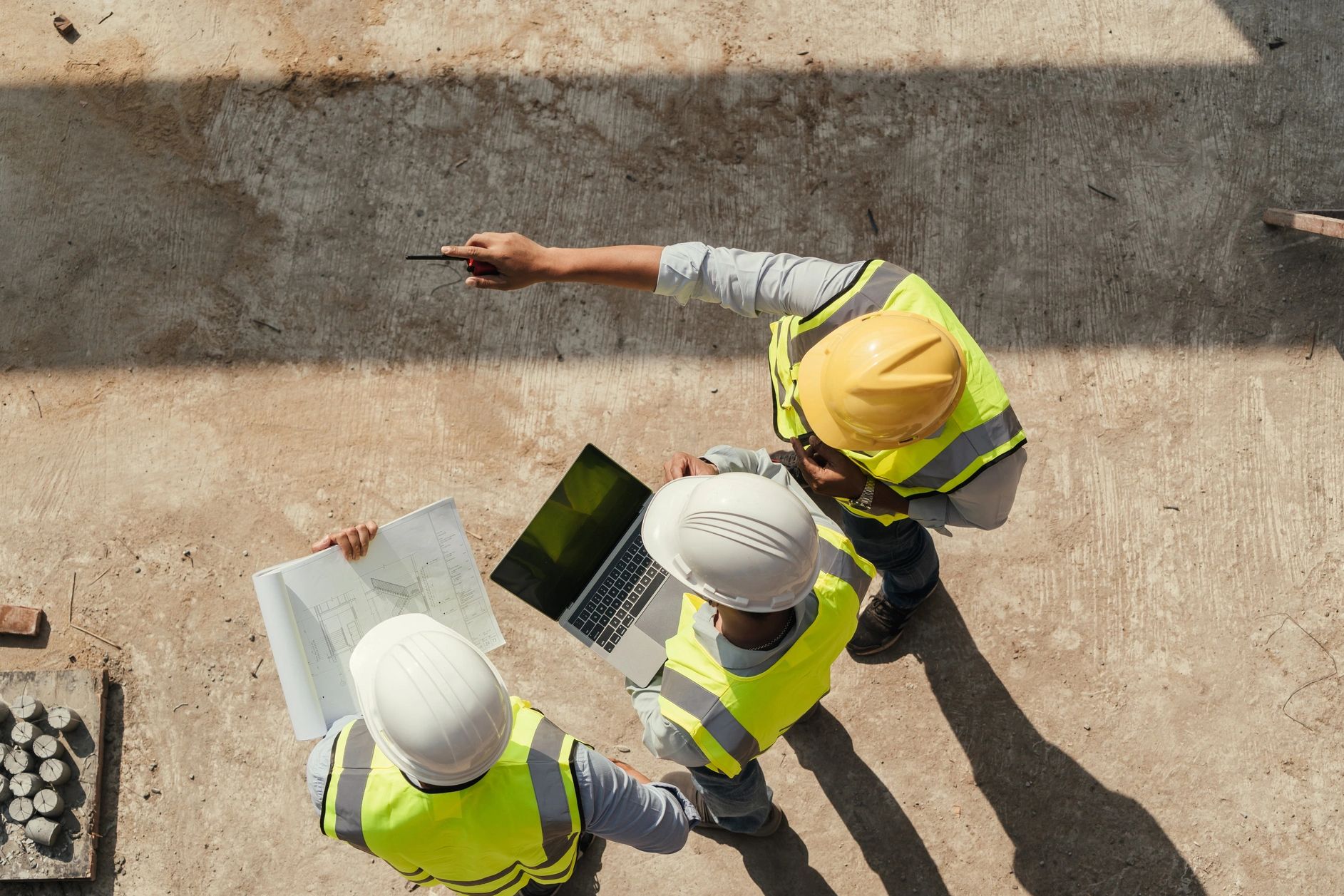 Construction workers discussing plans on a site.