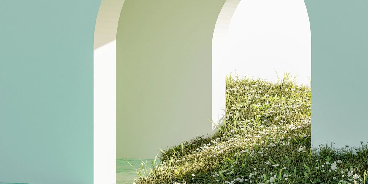 A serene archway with water and grassy hill dotted with white flowers.