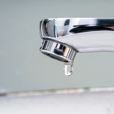 Close-up of a dripping chrome faucet.