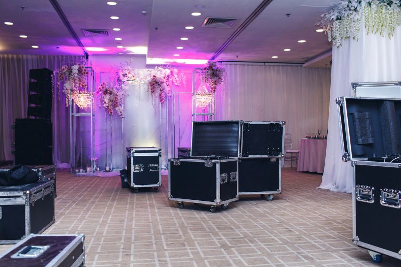 Black boxes for equipment on the background of the decor of the restaurant. The process of decorating a hall for a wedding banquet.