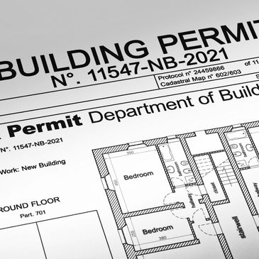 Close-up of a building permit document with architectural floor plans.