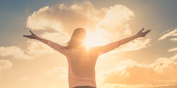 Joyful woman arms extended looking at sky after helping chronic lyme with glutathione in Owasso