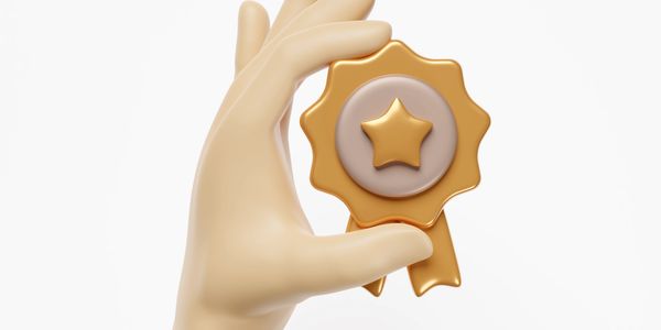 3D hand holding a gold award ribbon with a star.