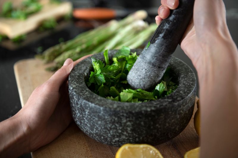 Grinding herbs with a mortar and pestle in the kitchen