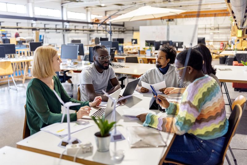 African businessman planning strategy with colleagues during meeting. Group of professionals collaborating on a new project at creative workplace.