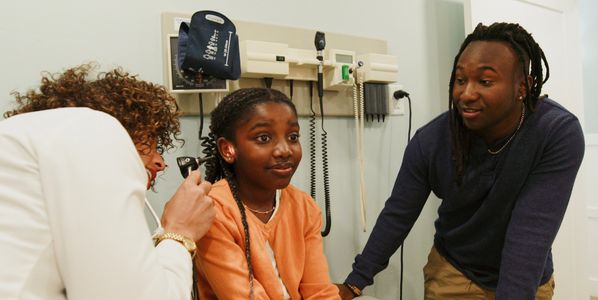 Person administering an injection into their abdomen with a pen-like device.