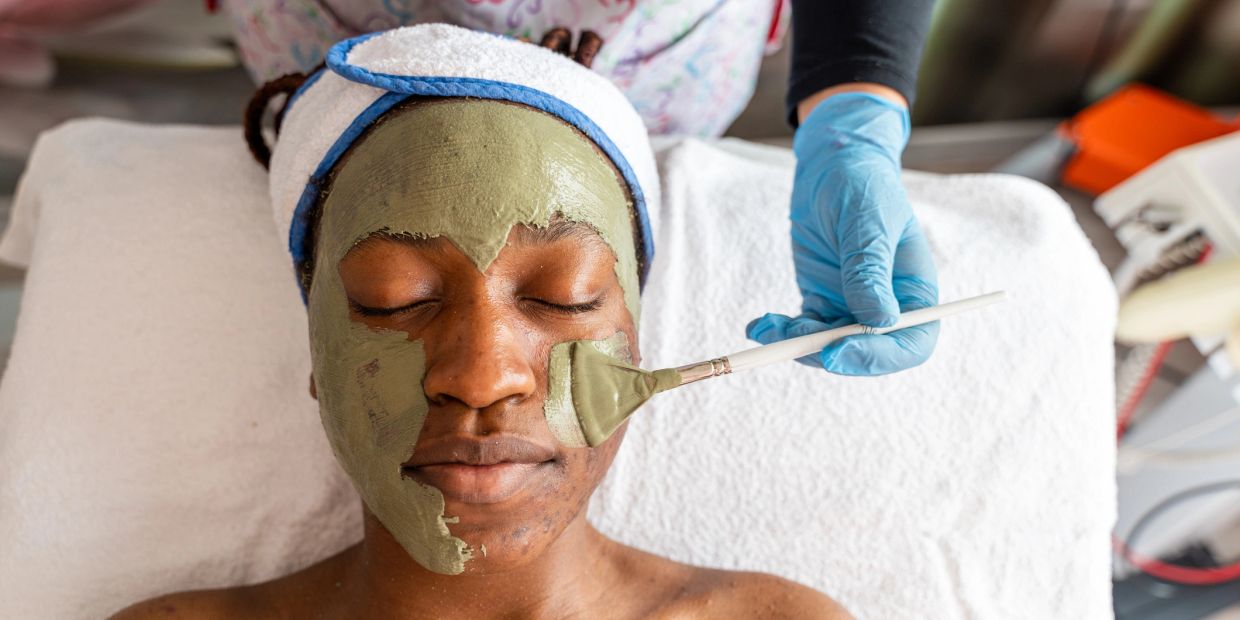 Woman receiving a facial mask treatment at a spa.