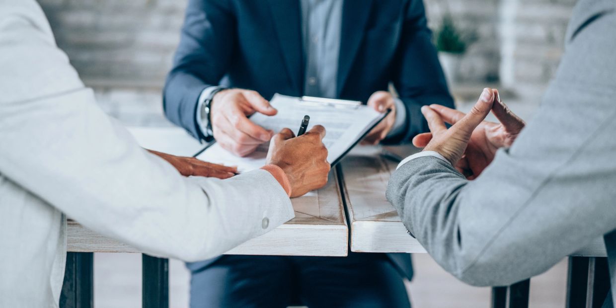 People in a business meeting signing documents.
