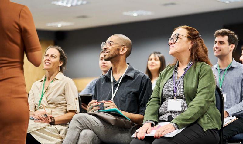 Multiracial group of businesspeople listening to a speaker during a conference event at convention center
