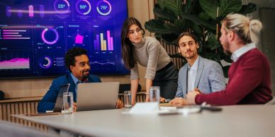 Four colleagues discussing data in a meeting room.