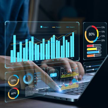 Person interacting with holographic data charts over laptop.