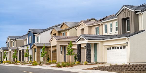 Row of modern suburban houses with varied designs and muted colors.
