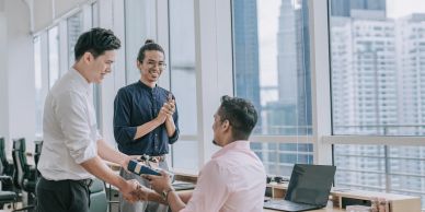 Colleagues exchanging a gift in an office.