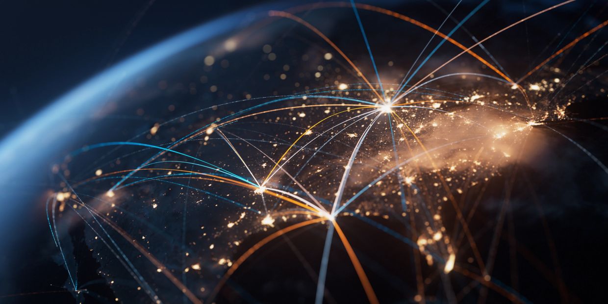 Glowing network connections between cities on a nighttime Earth view from space.
