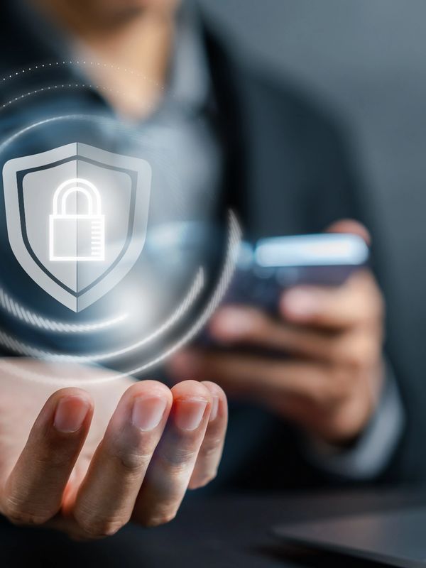 Person holding a smartphone with a digital security lock icon floating above their hand.