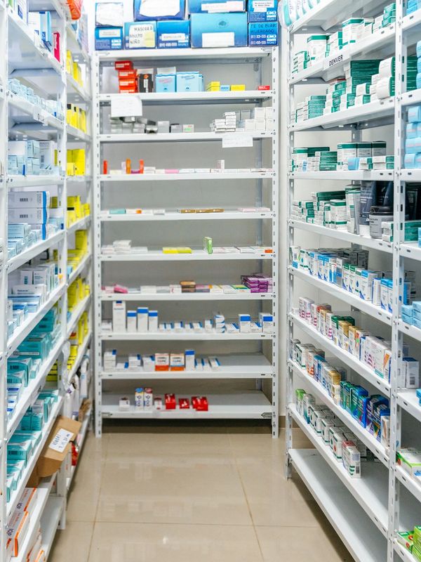Well-organized pharmacy shelves stocked with various medications and health products.