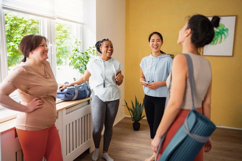 Group of multiracial women, talking and hangout at the yoga studio, before yoga class
