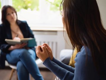 Woman consulting with a therapist in a cozy room.