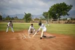 Children playing baseball on a sunny day at a local field.