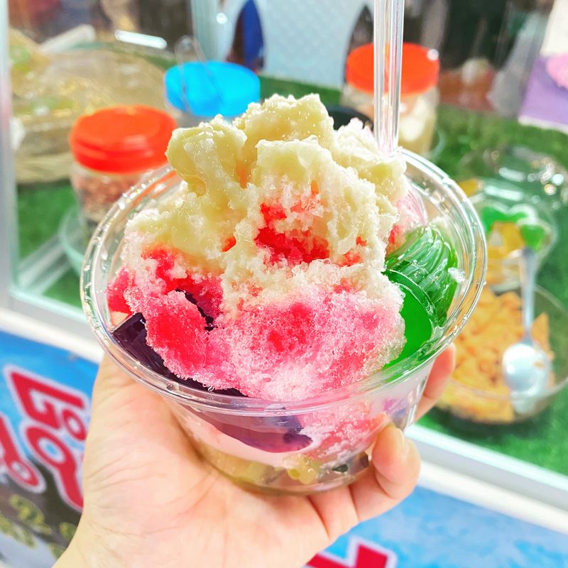 Brightly colored shaved ice topped with sweetened condensed milk is a great way to cool off the hot weather.
