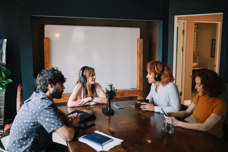 Group of people discussing themes on a live podcast from their studio in Los Angeles, California.