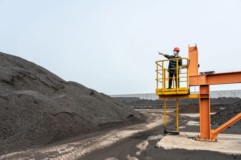 An Asian female technician works at a coal port