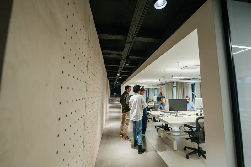 Photo of a group of coworkers having a  professional conversation and discussing business in the office