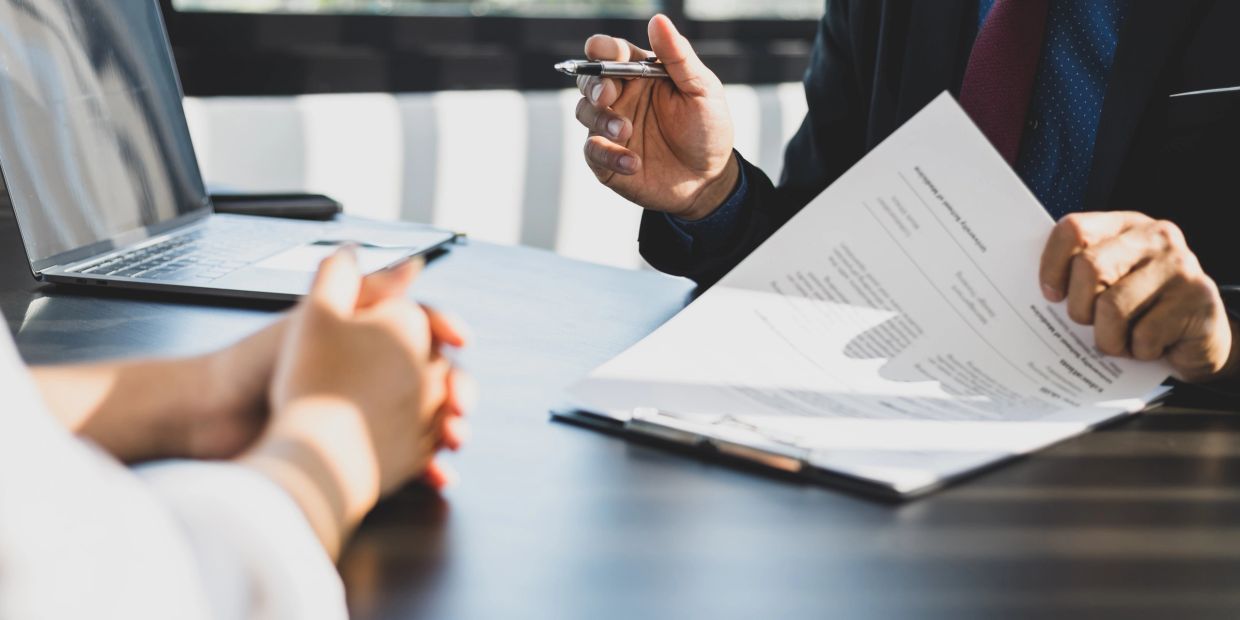 Two people discussing documents at a table.