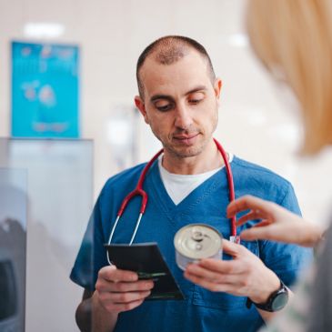 Doctor revisa etiqueta de bebida con paciente.