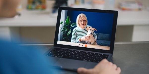 Video call with woman holding a dog.