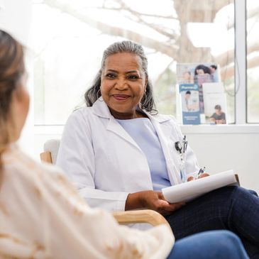 Smiling female doctor consulting a patient in a bright office.