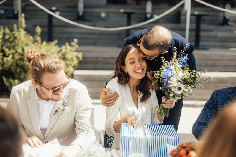 The bride and groom are dining at a table after the wedding