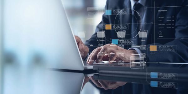 Person working on laptop with digital data and file icons overlay.