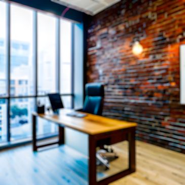 Modern office with wooden desk and brick wall.