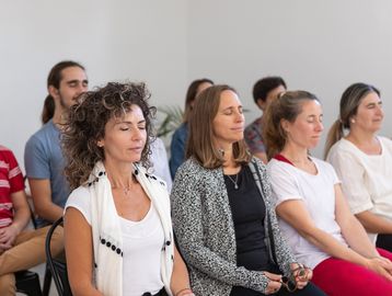 Group meditation session with peaceful expressions.