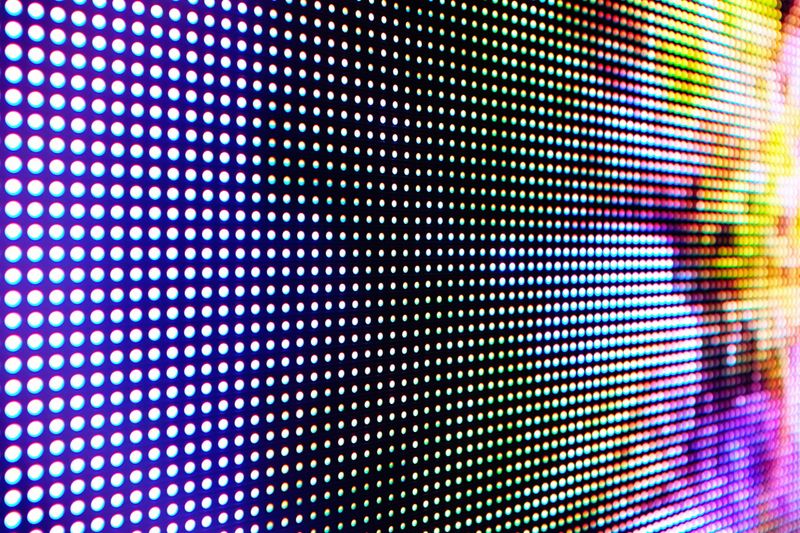 Abstract close-up view of a modern electronic billboard with pixels made up by light-emitting diodes.