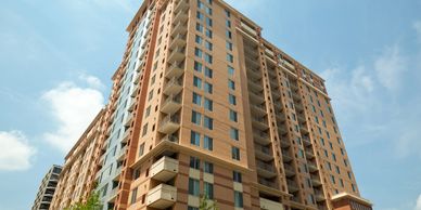 Tall modern apartment building under a clear blue sky.