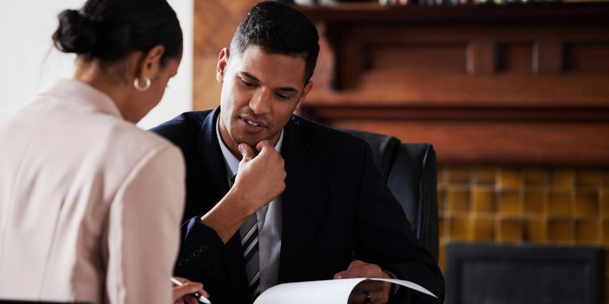 Two professionals reviewing documents in an office.