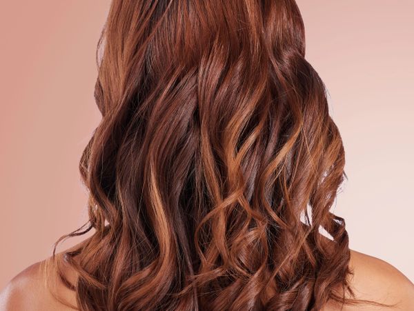 Back view of curly, reddish-brown hair with soft waves.