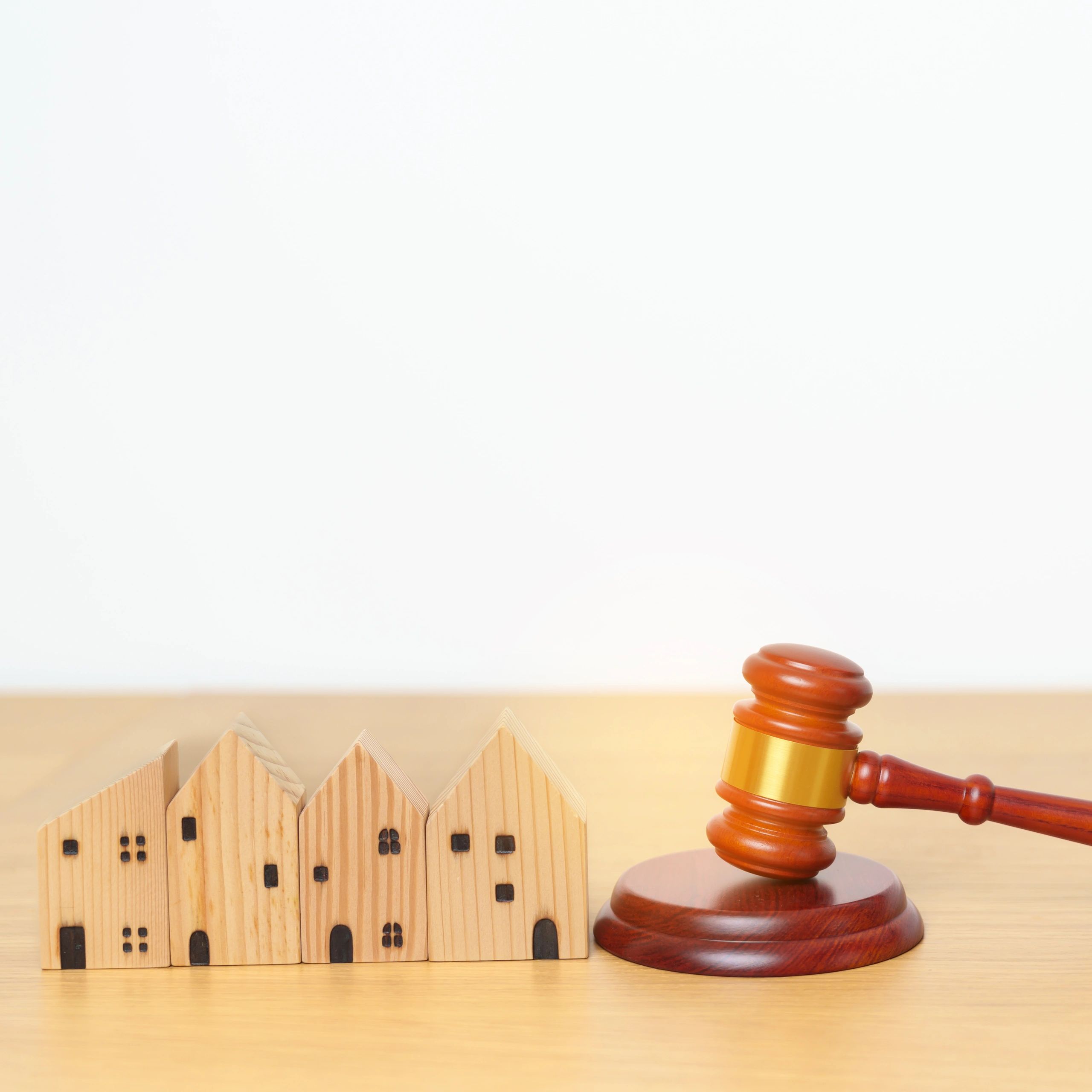 Wooden houses and a judge's gavel on a table.