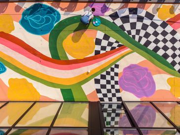 Colorful mural with a person painting.