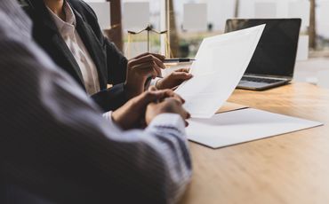 Two people reading document 