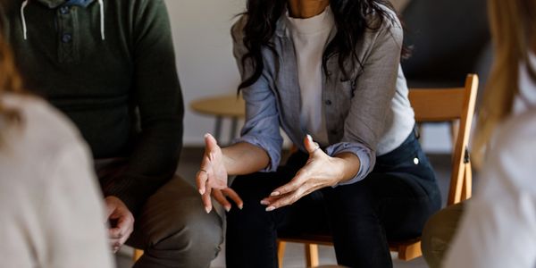 A woman speaking passionately in a small group meeting.