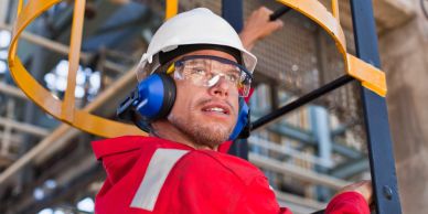 Worker wearing safety gear in industrial setting.
