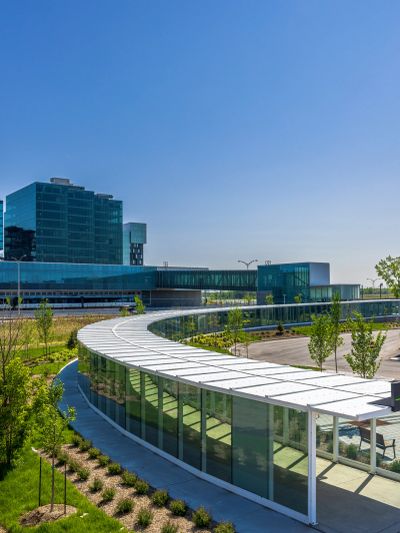 Bâtiment moderne avec une passerelle courbée en verre.