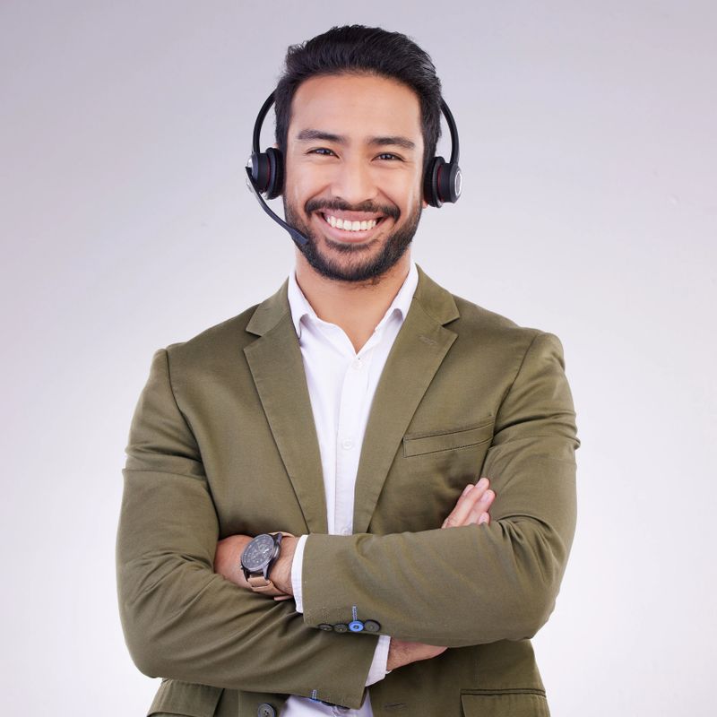 Call center employee, man with smile and arms crossed in portrait, headset with mic, CRM and contact us. Communication, customer service or tech support mockup with happy male on studio background