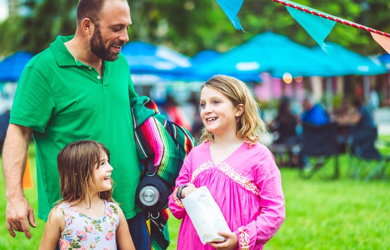 Kids share a snack at an outdoor festival