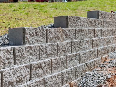 Constructed stone retaining wall on grassy slope.
