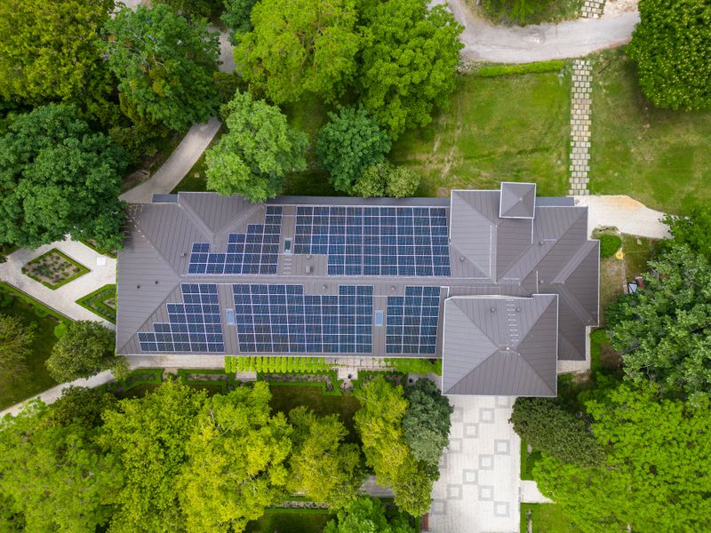 The modern house with a roof designed as a large solar panel, blending style and sustainability. Its sleek and functional design harnesses the sun's energy, powering the home. This architectural marvel exemplifies renewable energy integration and eco-conscious living.